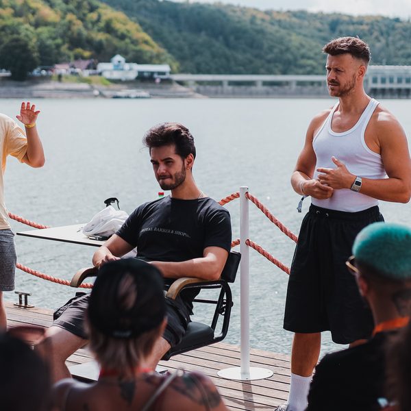 Lektor v bílém tílku vede školení na palubě lodi nad přehradou