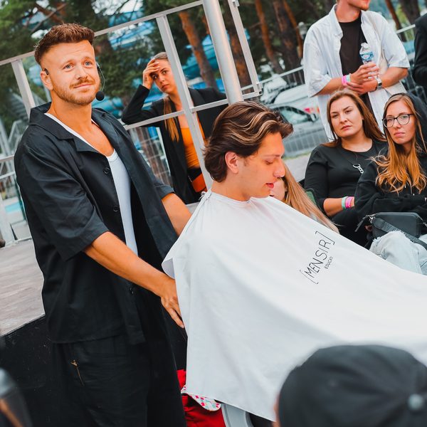 Lektor s headsetem pracuje na zákazníkovi v bílé pláštěnce před publikem