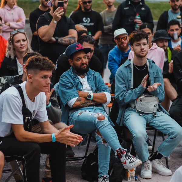 Diváci na židlích sledují školení, jeden v džínové bundě tleská
