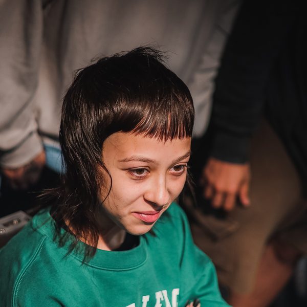 Modelka v zelené mikině s čerstvě ostříhaným mulletem a krátkou ofinou