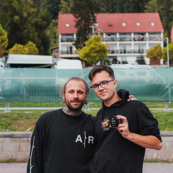 Dva barbeři pózují s kelímkem pomády před penzionem u pláže